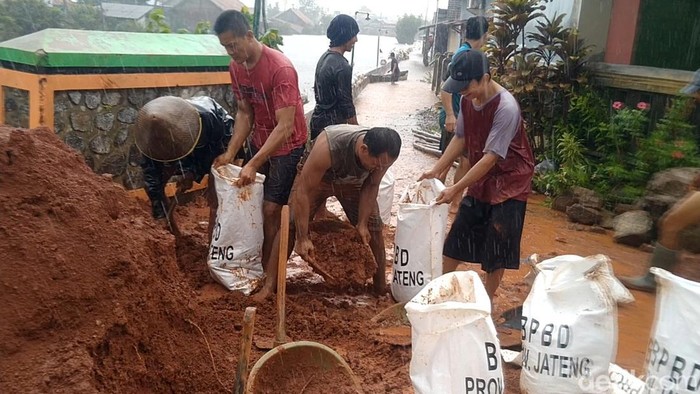 Hujan tidak menyurutkan TNI-Polri, Satpol PP dan warga menyelesaikan tanggul darurat di Kota Pekalongan untuk mengantisipasi banjir rob susulan, Kamis (26/5/2022).