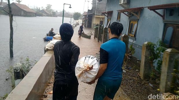 Hujan tidak menyurutkan TNI-Polri, Satpol PP dan warga menyelesaikan tanggul darurat di Kota Pekalongan untuk mengantisipasi banjir rob susulan, Kamis (26/5/2022).