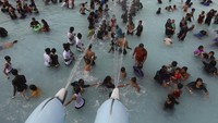 Kondisi suhu yang panas membuat warga India memilih mendinginkan diri dengan bermain air di kolam.
