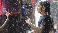 Tak sedikit warga yang mengajak serta anggota keluarga mereka untuk mendinginkan diri dengan bermain air di kolam yang berada di wilayah Hyderabad, India.
