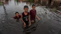 Sejumlah anak berjalan melewati banjir rob di Tirto Gang 12, Pekalongan, Jawa Tengah, Rabu (25/5/2022).