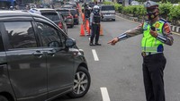 Petugas Sat Lantas Polres Bogor dan petugas Dishub Kabupaten Bogor mengarahkan kendaraan wisatawan saat penyekatan kendaraan nomor polisi ganjil genap di jalur wisata Puncak, Gadog, Kabupaten Bogor, Jawa Barat, Kamis (26/5/2022).
