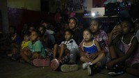 Pemutaran film di kawasan permukiman padat ini dinanti masyarakat, tak kecuali anak-anak. 