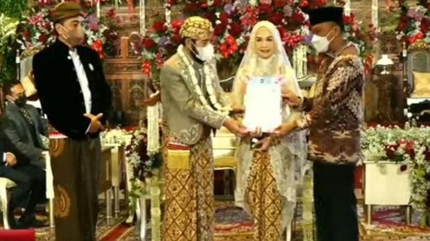 Penyerahan KTP baru Ketua MK Anwar Usman dan adik Jokowi, Idayati, usai menikah, Solo, Kamis (26/5/2022).