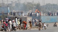 Tampak pendukung politik Pakistan Tehreek-e-Insaf (PTI) di Rawalpindi, menggunakan alat berat untuk memindahkan kontainer yang digunakan untuk memblokir jalan guna mencegah mereka menghadiri pawai protes yang direncanakan oleh mantan Perdana Menteri Pakistan Imran Khan di Islamabad, Rabu (25/5/2022). (REUTERS/Akhtar Soomro).