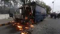 Di Karachi, aksi unjuk rasa diwarnai pembakaran mobil. Sebuah kendaraan polisi terbakar selama demonstrasi anti-pemerintah oleh para pendukung partai oposisi kunci Pakistan, Rabu (25/5/2022). (AP Photo/Fareed Khan).