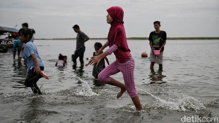 Pantai Ancol jadi salah satu destinasi wisata yang dituju warga Jakarta saat libur tanggal merah. Sejumlah anak terlihat asyik bermain air di pantai.