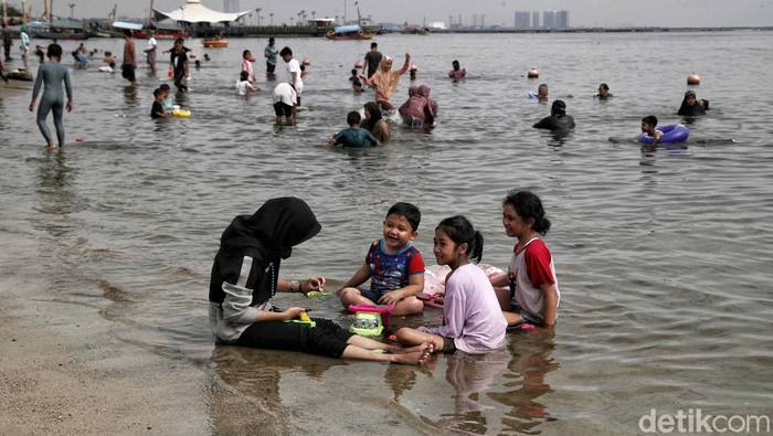 Pantai Ancol jadi salah satu destinasi wisata yang dituju warga Jakarta saat libur tanggal merah. Sejumlah anak terlihat asyik bermain air di pantai.
