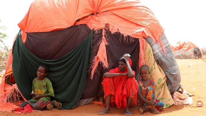 Amina Hassan Aden sits with her children Yonis Saleban, 1, Abdulahi Saleban, 3, and Isnino Saleban, 9, inside their makeshift shelter at the Kaxareey camp for the internally displaced people in Dollow, Gedo region of Somalia May 24, 2022. Picture taken May 24, 2022. REUTERS/Feisal Omar