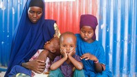 Amina Hassan Aden duduk bersama anak-anaknya Yonis Saleban, 1, Abdulahi Saleban, 3, dan Isnino Saleban, 9, di dalam tempat penampungan sementara mereka di kamp Kaxareey untuk para pengungsi internal di Dollow, wilayah Gedo Somalia 24 Mei 2022.