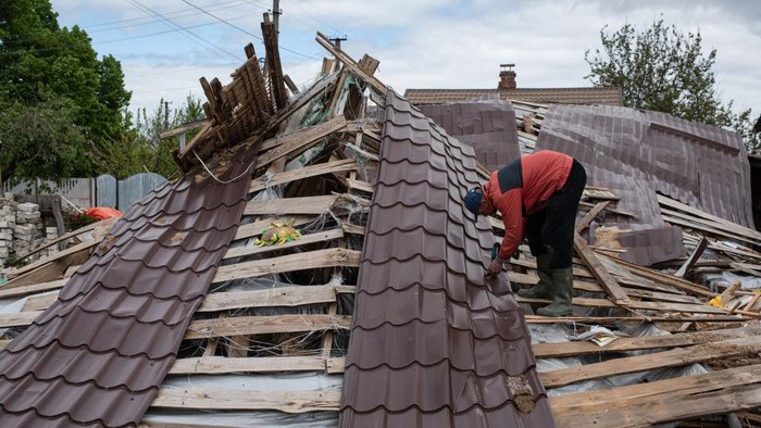 1240921553 NOVOSELIVKA, UKRAINE - MAY 26: Oleksandr, 43, disassembles the roof of his destroyed house on May 26, 2022 in Novoselivka, Ukraine. Chernihiv, northeast of Kyiv, was an early target of Russia's offensive after its February 24 invasion. While they failed to capture the city, Russian forces battered large parts of Chernihiv and the surrounding region in their attempted advance toward the capital. (Photo by Alexey Furman/Getty Images)