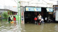 Warga menunggu banjir surut di sebuah warung di Paccinongan, Kecamatan Somba Opu, Kabupaten Gowa, Sulawesi Selatan, Jumat (27/5/2022).