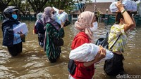 Sejumlah karyawan kawasan industri pelabuhan mengevakuasi dokumen perusahaan dari banjir rob.