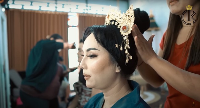 Menggunakan adat Bali, Kalina tampak mengenakan riasan kepala yang bernama Petitis. Petitis tersebut dipasang satu per satu ke rambut Kalina yang sudah disanggul. Foto: YouTube/Kalina Ocktaranny