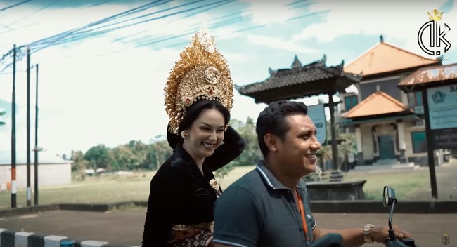 Menuju ke tempat lokasi pemotretan, Kalina yang sudah berdandan rapih mengenakan busana adat Bali tampak naik motor. Sambil terus memegangi hiasan kepalanya, Kalina terlihat tertawa bahagia. Foto: YouTube/Kalina Ocktaranny