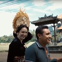 Menuju ke tempat lokasi pemotretan, Kalina yang sudah berdandan rapih mengenakan busana adat Bali tampak naik motor. Sambil terus memegangi hiasan kepalanya, Kalina terlihat tertawa bahagia. Foto: YouTube/Kalina Ocktaranny