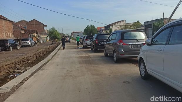 Kendaraan warga terdampak banjir rob terparkir di jalan akses utama Desa Sriwulan, Kecamatan Sayung, Demak, Jumat (27/5/2022).