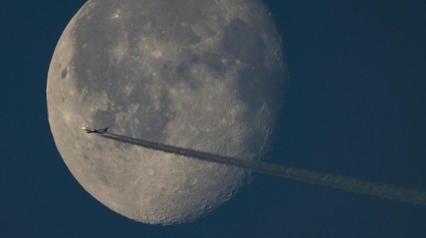 Sebuah pesawat terbang di langit London dengan latar belakang bulan purnama yang tak terlupakan. (Dan Kitwood/Getty Images). Sebuah pesawat terbang di langit London dengan latar belakang bulan purnama yang tak terlupakan. (Dan Kitwood/Getty Images).