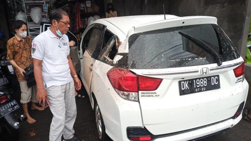 Mobil tertimpa pohon tumbang di Jalan Dewi Sri, Desa Legian, Kecamatan Kuta, Kabupaten Badung, Bali, Kamis (26/5).