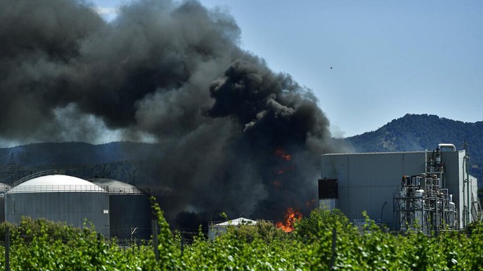Black smoke billows from a biodiesel production plant in Calahorra, northern Spain, Thursday, May 26, 2022. Police in Spain say an explosion at a biodiesel plant has left two people dead and forced 250 children to be evacuated from the area. (AP Photo/Alvaro Barrientos)