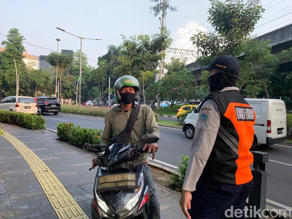 Petugas Dishub DKI menghalau pemotor bandel di trotoar sekitar Metropole, Jakarta Pusat. (Mulia Budi/detikcom)