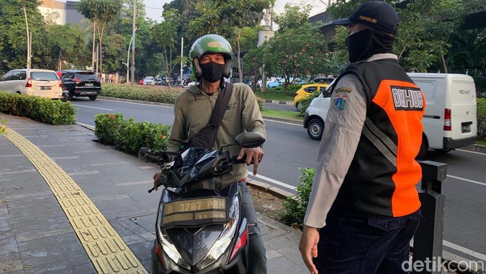 Petugas Dishub DKI menghalau pemotor bandel di trotoar sekitar Metropole, Jakarta Pusat. (Mulia Budi/detikcom)