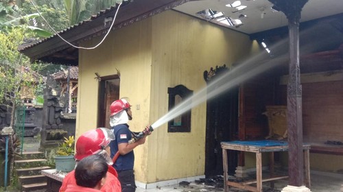 Petugas memadamkan api yang membakar bale gede di rumah salah seorang warga Banjar Samsam I, Desa Samsam, Kecamatan Kerambitan, Tabanan, Bali.