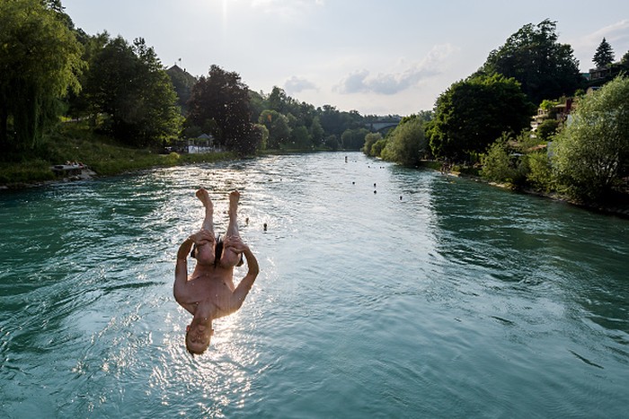 TOPSHOT - Young men jump into the river Aare on June 21, 2017 in Bern.

Europe sizzled in a continent-wide heatwave with London bracing for Britains hottest June day since 1976 as Portugal battled to stamp out deadly forest fires. Cooler weather was aiding their efforts, but thermometers were still hovering around 35 degrees Celsius (95 degrees Fahrenheit) -- a level matched across oven-like swathes of Europe, including Italy, Austria, the Netherlands and even alpine Switzerland. / AFP PHOTO / Fabrice COFFRINI        (Photo credit should read FABRICE COFFRINI/AFP)