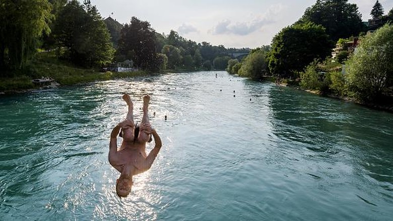 TOPSHOT - Young men jump into the river Aare on June 21, 2017 in Bern.

Europe sizzled in a continent-wide heatwave with London bracing for Britains hottest June day since 1976 as Portugal battled to stamp out deadly forest fires. Cooler weather was aiding their efforts, but thermometers were still hovering around 35 degrees Celsius (95 degrees Fahrenheit) -- a level matched across oven-like swathes of Europe, including Italy, Austria, the Netherlands and even alpine Switzerland. / AFP PHOTO / Fabrice COFFRINI        (Photo credit should read FABRICE COFFRINI/AFP)