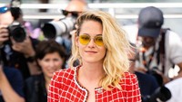 Kristen Stewart tampak cantik mengenakan setelan blouse berwarna dominasi merah dan putih dengan motif kotak-kotak.  Foto: WireImage/Samir Hussein