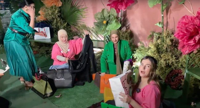 Setelah selesai mengambil kadonya masing-masing, ketiganya pun membuka isi kado tersebut. Rupanya kadonya itu sebagian besar berisi pakaian. Foto: YouTube/Tasya Farasya