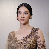 Kebaya lengan panjang berwarna hijau dan gold itu memiliki potongan kerah berbentuk v. Salah satu lengannya terdapat tambahan kain tile menjuntai dari bagian bahunya yang mempermanis tampilan kebaya. Foto: Instagram