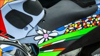 Drudi tetap mempertahankan kelir biru dan merah sebagai ciri khas Gresini Racing. Lalu ada ornamen berwarna cerah serta sejumlah gambar seperti hamparan bukit hijau Sirkuit Mugello, awan, pelangi, hingga bunga. Foto: Pool (Twitter)