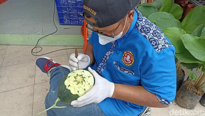 Perajin asal Blitar sedang mengukir buah
