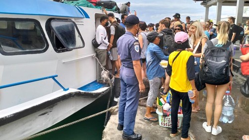 Sejumlah wisatawan saat akan menyebrang melalui Dermaga Rakyat Pelabuhan Padangbai, Karangasem, Bali, Sabtu (28/5/2022).