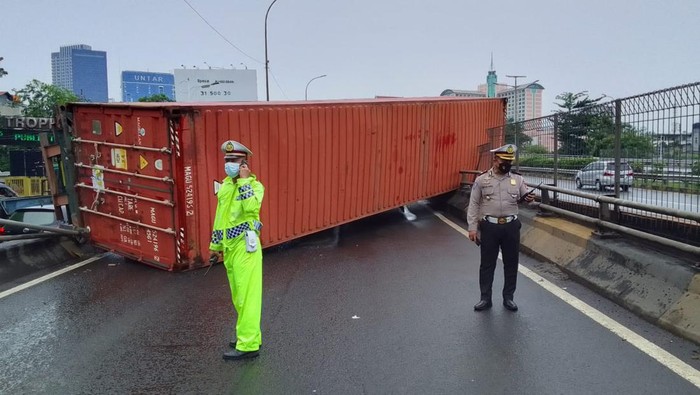 Truk kontainer terguling di flyover Tomang sejak Jumat (27/5) malam hingga pagi ini belum selesai dievakuasi