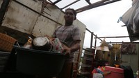Atap rumah yang rusak akibat dihantam angin kencang membuat warga menyelamatkan barang-barangnya untuk diungsikan ke tempat yang lebih aman. ANTARA FOTO/Irwansyah Putra.