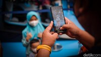 Tampak warga berhenti sejenak untuk mengabadikan foto bersama replika mobil balap listrik itu. 