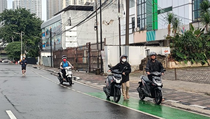 Warga menuntun motornya di lokasi CFD Jalan Tomang