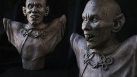 Yakin berani memotong patung kue yang satu ini? Dipoles seperti logam, tampilan kue ini jadi semakin mengintimidasi dan menyeramkan. Foto: Pool/Site