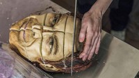 Dipotong dengan hati-hati, ukiran sempurna dari mata dan wajah yang ada di kue ini. Membuat siapapun yang memotong kue ini merasa diawasi. Foto: Pool/Site