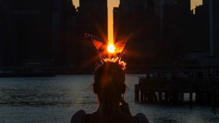 1233806519 NEW YORK, NY - JULY 4: A view of the 'Manhattanhenge' sunset as people are gathered in Long Island City to watch MacyΓ’s 4th of July Fireworks in New York City, United States on July 4, 2021. (Photo by Tayfun Coskun/Anadolu Agency via Getty Images)