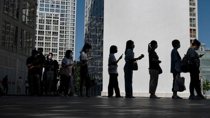 1400032018 BEIJING, CHINA -MAY 30: Office workers wait in line to show their health codes and proof of 48 hour negative nucleic acid test, outside an office building after some people returned to work, in the Central Business District on May 30, 2022 in Beijing, China. China is trying to contain a spike in coronavirus cases in Beijing after hundreds of people tested positive for the virus in recent weeks. Local authorities have initiated mass testing, mandated proof of a negative PCR test within 48 hours to enter many public spaces, closed schools and banned gatherings and inside dining in all restaurants, and locked down many neighborhoods in an effort to maintain the countrys zero COVID strategy. Due to improved control and lower numbers of new cases and reduced spread, municipal officials from Sunday permitted the easing of some restrictions to allow for limited return to office, resumption of public transport, and the re-opening of many shopping malls, parks, and scenic spots with limited capacity in some districts. (Photo by Kevin Frayer/Getty Images)