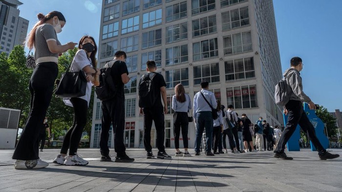 BEIJING, CHINA -MAY 30: Office workers wait in line to show their health codes and proof of 48 hour negative nucleic acid test, outside an office building after some people returned to work, in the Central Business District on May 30, 2022 in Beijing, China. China is trying to contain a spike in coronavirus cases in Beijing after hundreds of people tested positive for the virus in recent weeks. Local authorities have initiated mass testing, mandated proof of a negative PCR test within 48 hours to enter many public spaces, closed schools and  banned gatherings and inside dining in all restaurants, and locked down many neighborhoods in an effort to maintain the countrys zero COVID strategy. Due to improved control and lower numbers of new cases and reduced spread, municipal officials from Sunday permitted the easing of some restrictions to allow for limited return to office, resumption of public transport, and the re-opening of many shopping malls, parks, and scenic spots with limited capacity in some districts. (Photo by Kevin Frayer/Getty Images)