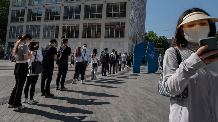BEIJING, CHINA -MAY 30: Office workers wait in line to show their health codes and proof of 48 hour negative nucleic acid test, outside an office building after some people returned to work, in the Central Business District on May 30, 2022 in Beijing, China. China is trying to contain a spike in coronavirus cases in Beijing after hundreds of people tested positive for the virus in recent weeks. Local authorities have initiated mass testing, mandated proof of a negative PCR test within 48 hours to enter many public spaces, closed schools and  banned gatherings and inside dining in all restaurants, and locked down many neighborhoods in an effort to maintain the countrys zero COVID strategy. Due to improved control and lower numbers of new cases and reduced spread, municipal officials from Sunday permitted the easing of some restrictions to allow for limited return to office, resumption of public transport, and the re-opening of many shopping malls, parks, and scenic spots with limited capacity in some districts. (Photo by Kevin Frayer/Getty Images)
