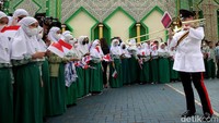 Para santri tampak mengibarkan bendera Indonesia dan bendera Inggris berukuran mini saat menyaksikan penampilan band militer tersebut.