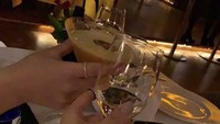 Momen minum-minum cantiknya juga terlihat dalam foto ini. Memegang gelas cocktail dan wine, ia tampaknya sedang santap di restoran fine dining.