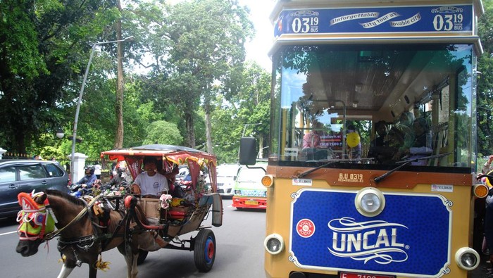 BUS WISATA UNCAL BOGOR KEMBALI BEROPERASI Pengemudi delman melewati bus wisata Uncal di jalan Juanda, Kota Bogor, Jawa Barat, Minggu (29/5/2022). Pemerintah Kota Bogor kembali mengoperasikan layanan bus wisata Uncal secara gratis kepada masyarakat luas setiap akhir pekan pasca melandainya pandemi COVID-19. ANTARA FOTO/Arif Firmansyah/nz