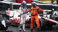 Mick Schumacher dibantu oleh seorang marshal untuk menjauh dari mobilnya usai insiden kecelakaan.