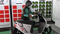 Pengemudi ojek daring mengganti baterai sepeda motor listriknya di stasiun pengisian baterai listrik di Kuningan, Jakarta, Senin (30/5/2022).
